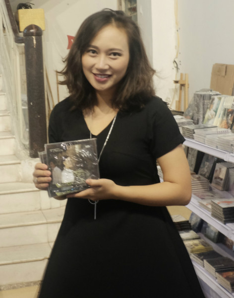 Khánh Linh để con gái cho chồng giữ và tranh thủ đi chọn đĩa. Cô xúc động khi gặp lại những sản phẩm cũ của mình như album 