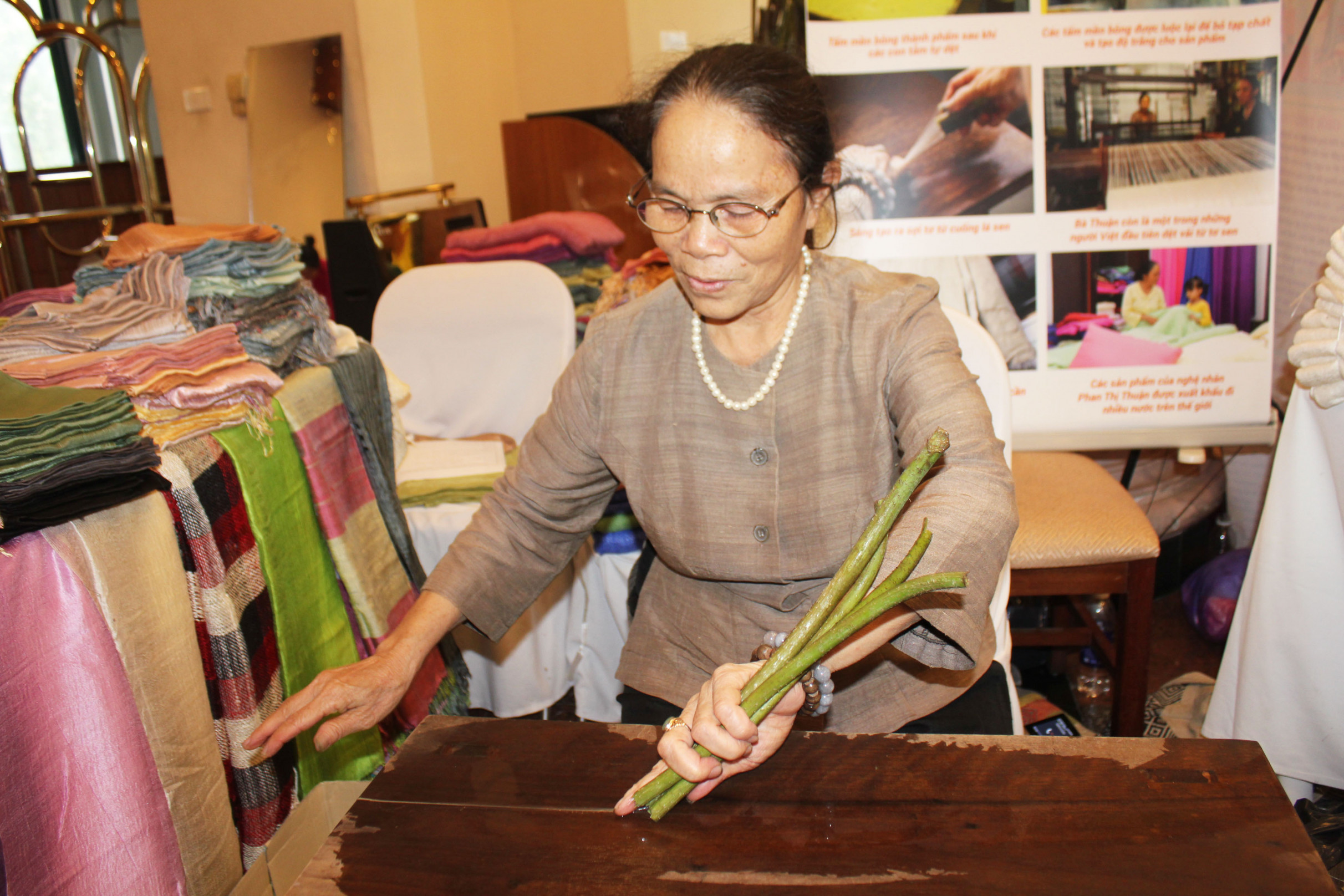 Nghệ nhân ưu tú Phan Thị Thuận đang lấy sợi tơ từ cuống lá, cuống hoa của cây sen. Sợi sen thu được rất nhẹ và có mùi thơm tự nhiên. Từ sợi tơ sen sẽ kết hợp với sợi tơ tằm, từng bước áp dụng đưa vào sản xuất.