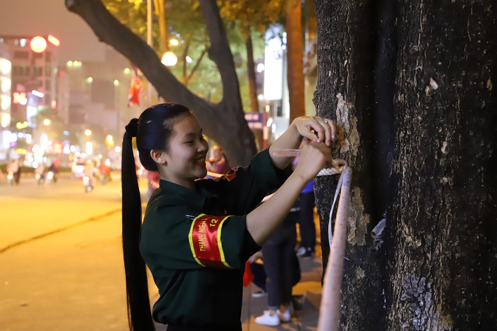 Nguyễn Thị Phương Thảo, nữ sinh trường Đại học Lao động Xã hội, cùng với đội sinh viên tình nguyện có mặt từ rất sớm để hỗ trợ công tác chuẩn bị. Nữ sinh này đang buộc lại hàng rào an ninh trước giờ đón Tổng thống Mỹ.
