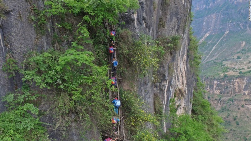 Hình ảnh ấn tượng về 15 học sinh 6 tuổi mạo hiểm leo từ đỉnh ngọn núi nơi có ngôi làng Atule'er của các em qua 17 chiếc thang thô sơ dọc vách núi cao 800m để đến trường.