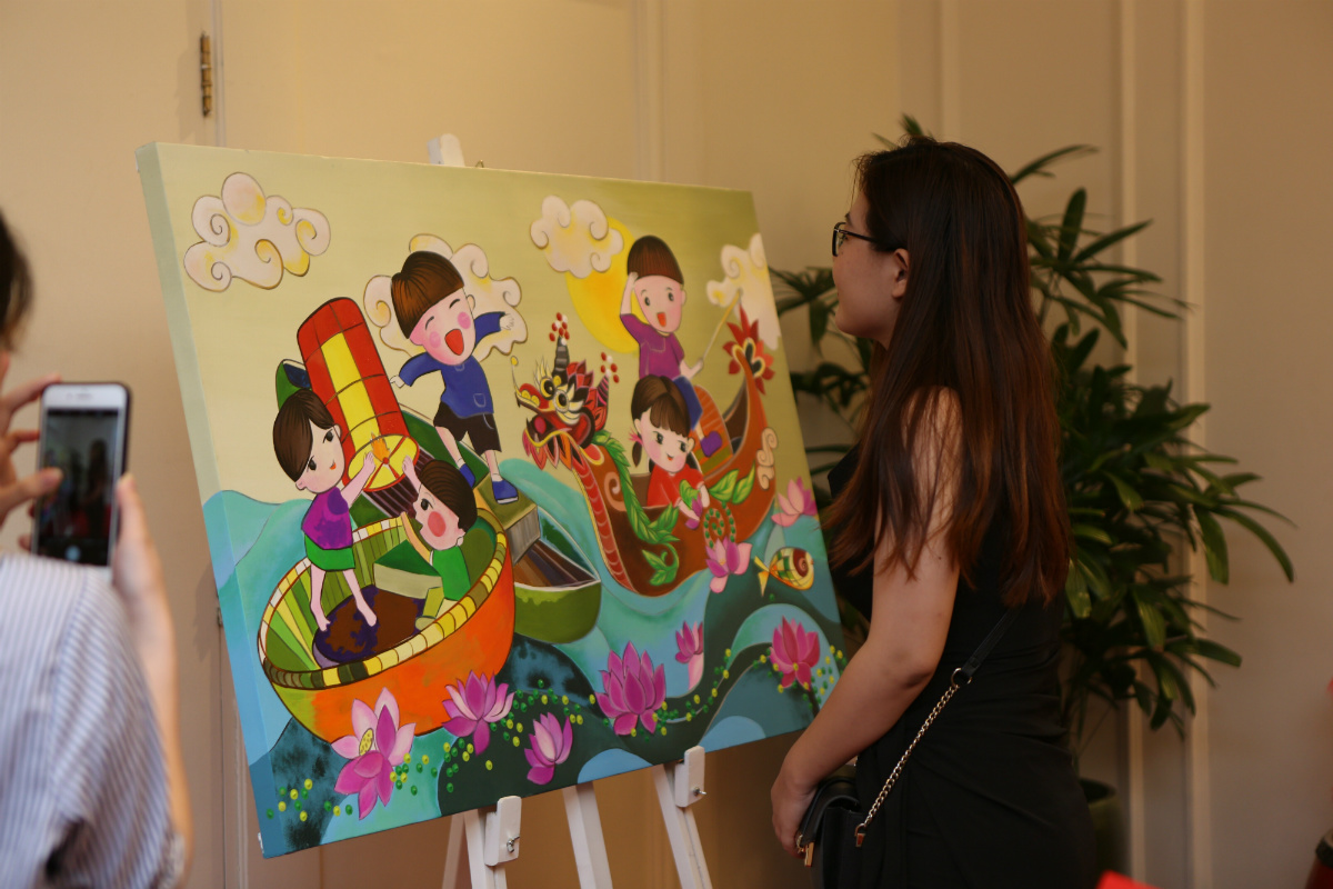 Cô gái trẻ thích thú chiêm ngưỡng bộ tranh của họa sĩ Nguyễn Duy Nghiên