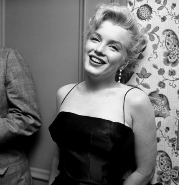 Diện chiếc đầm hai dây gam đen gợi cảm, nữ diễn viên khoe nụ cười rạng rỡ trong bữa tiệc được tổ chức tại nhà riêng của cô vào năm 1956.
