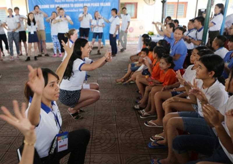 Trong bầu không khí thân thiện và ấm cúng, các thanh niên APEC gần gũi với các em nhỏ, bày tỏ tình cảm với các em bằng ngôn ngữ ký hiệu.