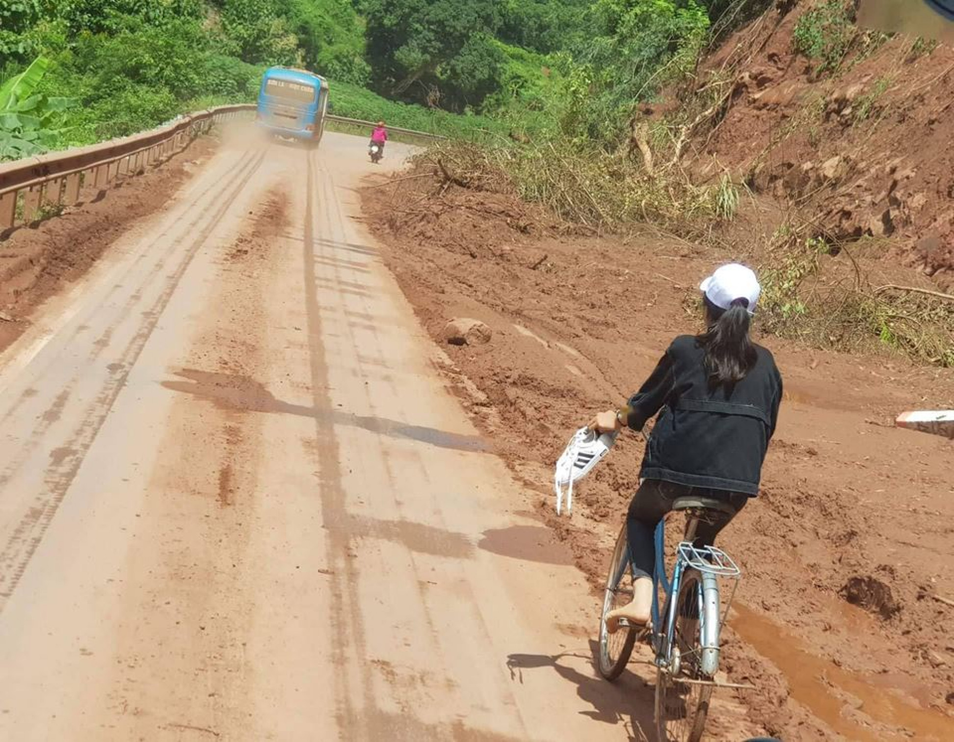 Đặc biệt, hôm nay là ngày khai trường, các em học sinh phải bỏ giày, xăn quần qua những con đường đất lầy lội để giữ sạch trang phục. 