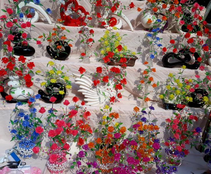 Ngoài hoa lụa còn có các loại hoa kết từ hạt vòng nhiều màu, với giá từ 150.000 đồng/bình.  