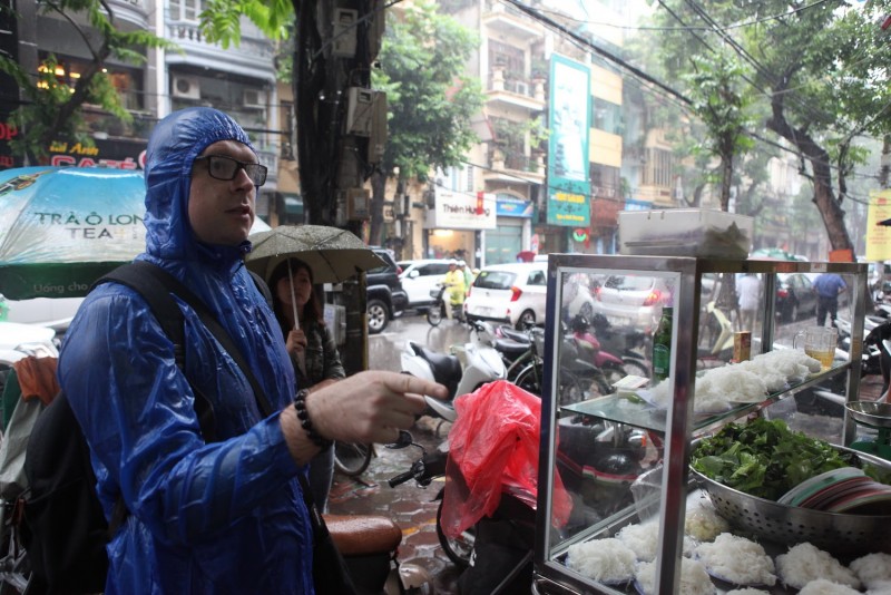 Một vị khách đội mưa đến quán bún chả Hương Liên.