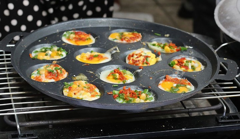Món bánh trứng cút nướng với một số nguyên liệu như trứng cút bò khô, hành hoa, đậu phộng nóng hổi được chế biến đẹp mắt, thơm ngon.
