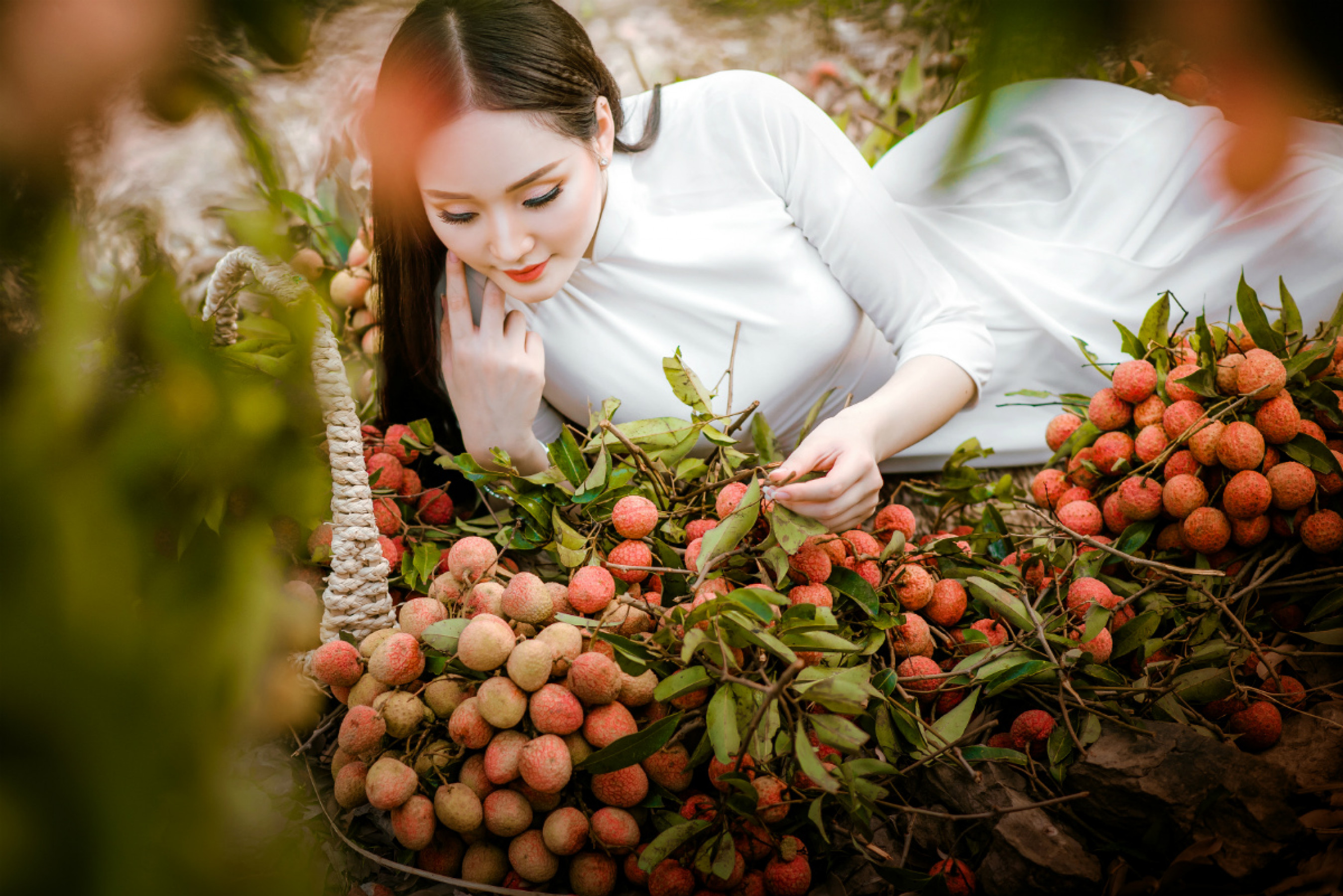 Những chùm vải căng mọng của núi đồi Lục Ngạn rất hài hòa, ăn nhịp với vẻ đẹp thanh xuân tràn đầy sức sống của Nguyễn Oanh. 