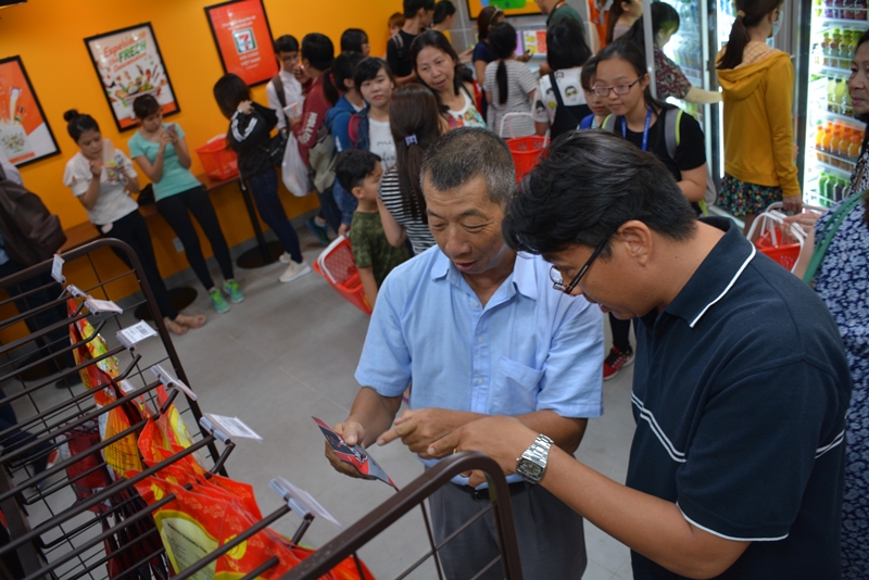 Người tiêu dùng đang lựa mua sản phẩm tại cửa hàng tiện lợi 7-Eleven đầu tiên ở Việt Nam.