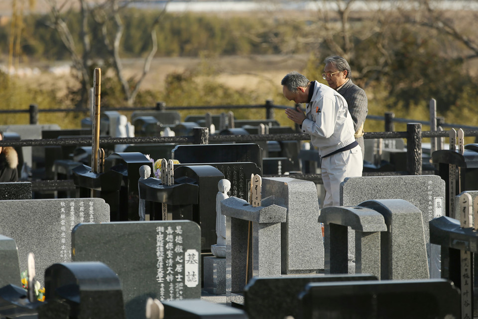 Thân nhân thắp nén nhang cho một người thiệt mạng tại nghĩa trang ở Fukushima, được xây cho những nạn nhân trong vụ thảm hoạ hồi tháng 3/2011. 