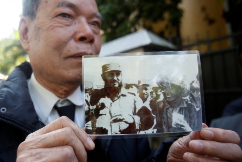 Ông Cao Khắc Thuận, từng học tập tại Cuba, cầm bức ảnh ông chụp chung với lãnh tụ Fidel Castro năm 1967. Ảnh: Reuters.