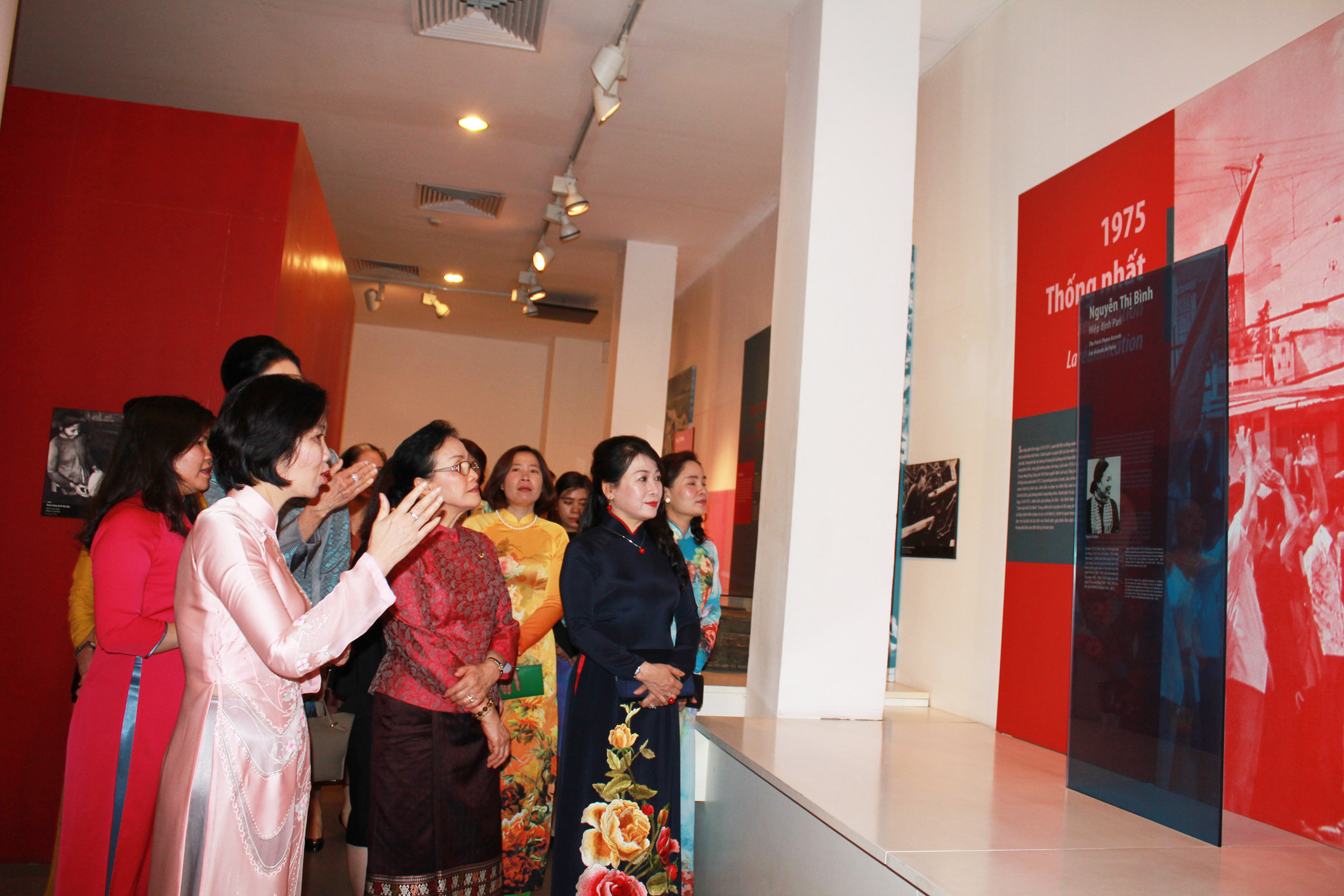Các phu nhân chăm chú ngắm nhìn bức ảnh của nguyên Phó Chủ tịch nước Nguyễn Thị Bình và đọc những dòng chữ viết về những đóng góp của bà trong lịch sử Việt Nam.
