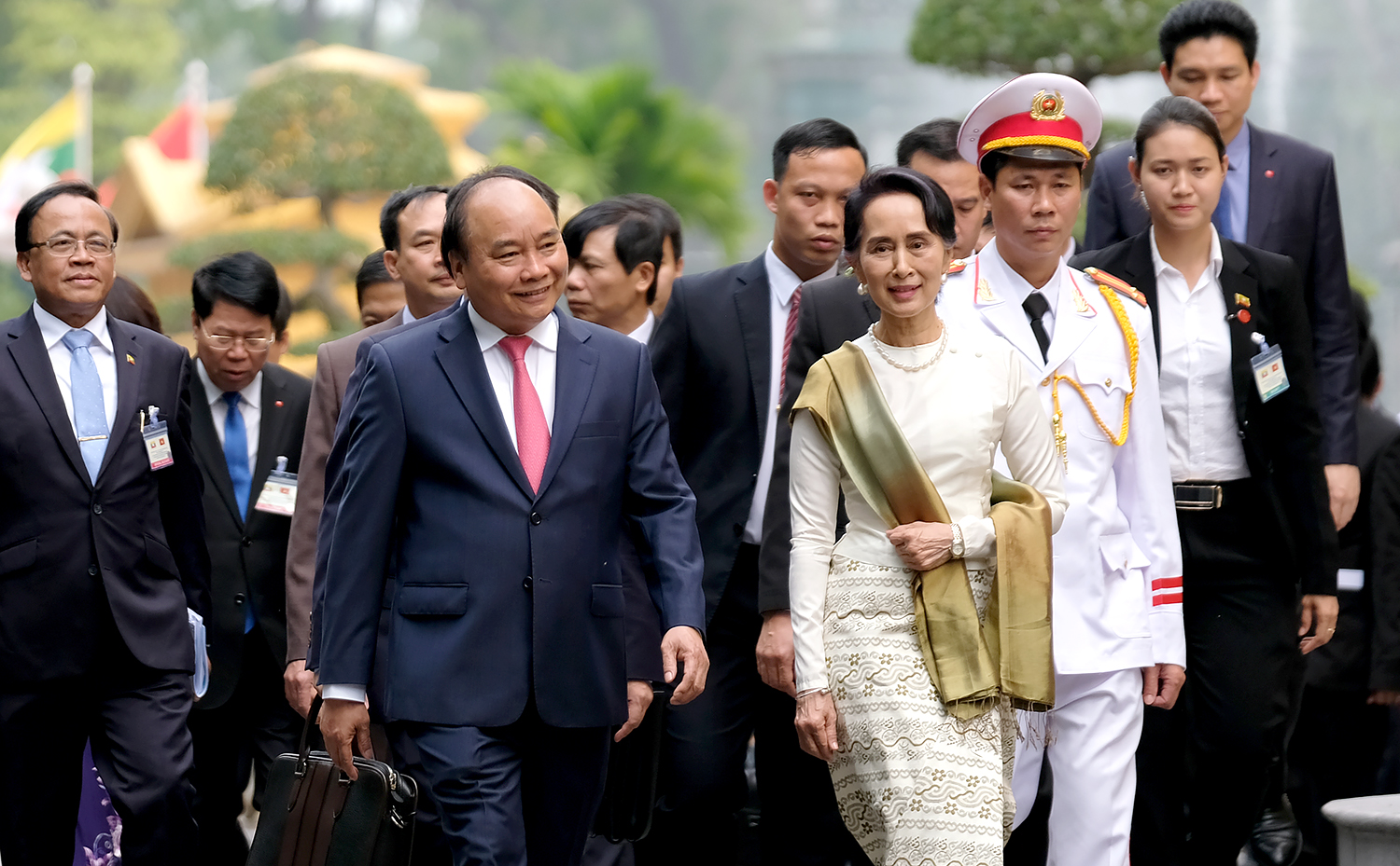 Cùng đi với bà Aung San Suu Kyi có: Ông Thant Sin Maung, Bộ trưởng Bộ Giao thông và Truyền thông; ông Kyaw Tin, Bộ trưởng Bộ Hợp tác quốc tế; ông Min Thu, Thứ trưởng Bộ Văn phòng Tổng thống; ông Sett Aung, Thứ trưởng Bộ Kế hoạch và Tài chính.