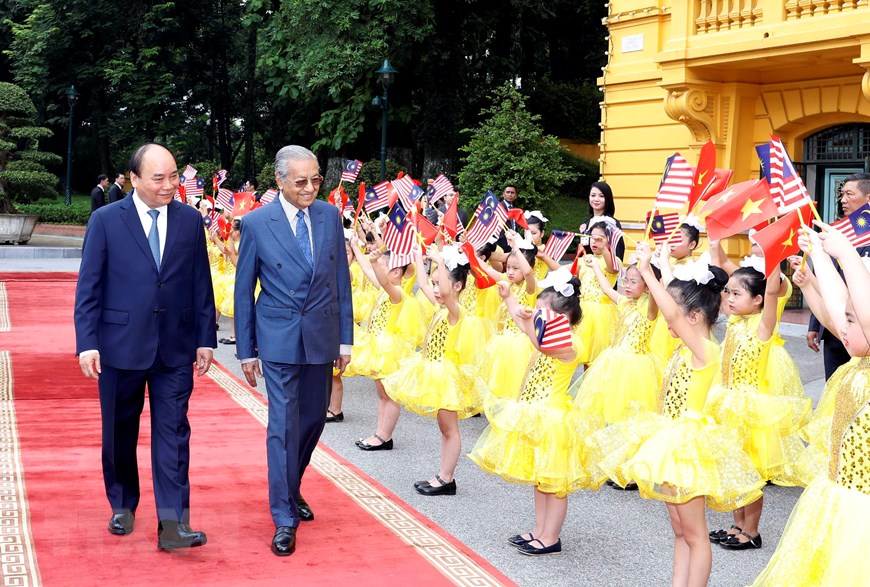 Thủ tướng Nguyễn Xuân Phúc và Thủ tướng Malaysia Mahathir Mohamad với thiếu nhi Thủ đô Hà Nội tại Lễ đón. (Ảnh: Thống Nhất/TTXVN)