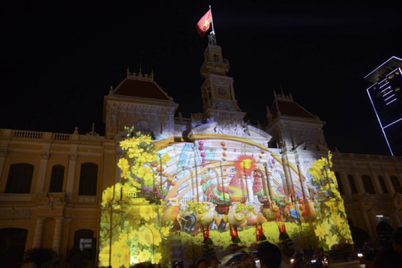 Nằm trong khu vực đường hoa Nguyễn Huệ, màn biểu diễn ánh sáng nghệ thuật trên tòa nhà UBND TP HCM thu hút hàng nghìn người đến xem. Nguồn: Vietnamnet
