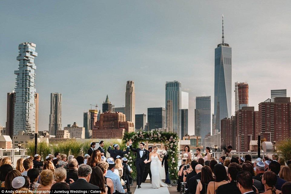 Bức ảnh được chụp tại New York bởi nhiếp ảnh gia Andy Gaines, cho thấy một cặp vợ chồng kết hôn trong một buổi lễ Do Thái với đường chân trời của thành phố rộng mở phía sau họ.