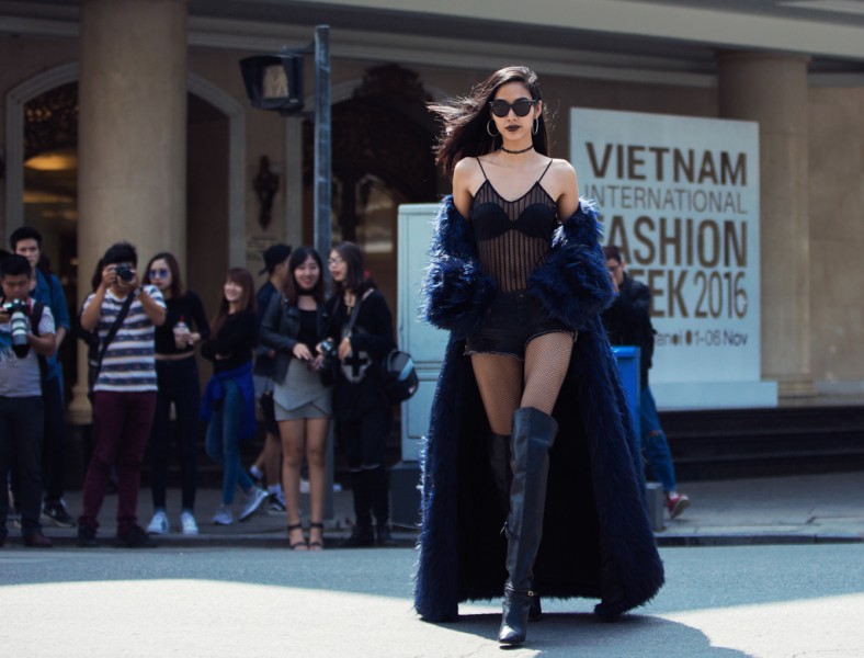 Hoàng Thuỳ xuất hiện trong sự kiện thời trang đường phố trong khuôn khổ Tuần lễ thời trang Quốc tế với áo bra lưới, quần sooc cùng áo choàng lông trễ vai bên ngoài