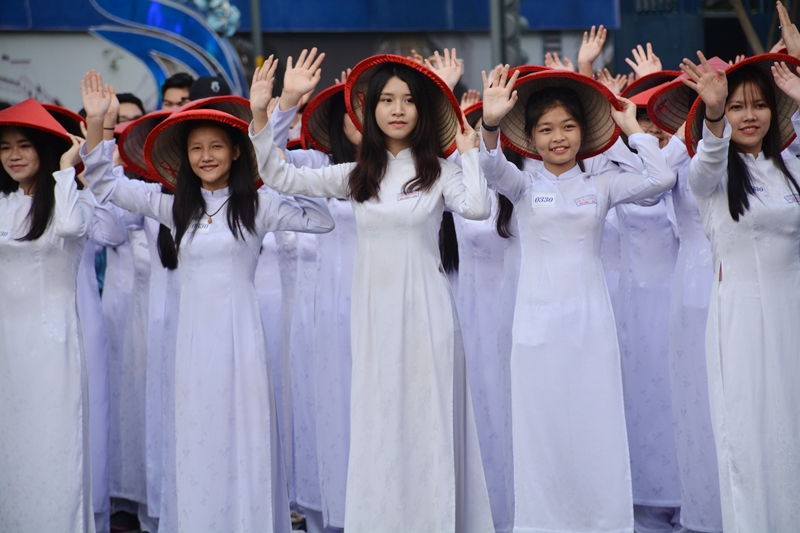 Các nữ sinh vẫy chào người dân, du khách nước ngoài trong tiết mục đồng diễn đầy ấn tượng tôn vinh tà áo dài truyền thống của dân tộc.
