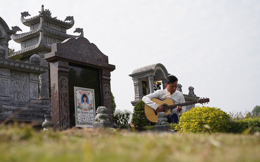Người đàn ông ngồi hát bên mộ vợ trong lễ tạ mộ ngày cuối năm