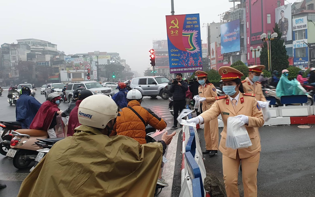 Chùm ảnh: Công an Hà Nội đội mưa phát khẩu trang cho người dân
