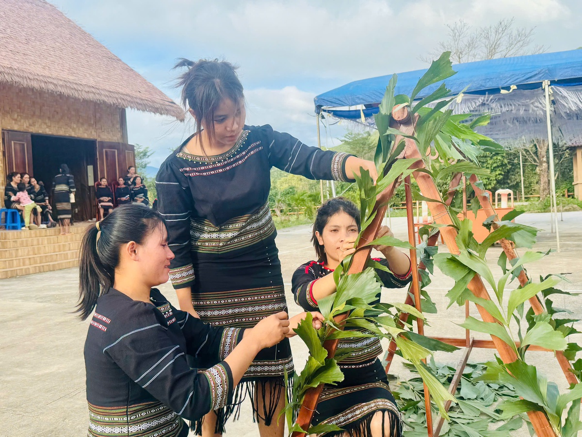 Chị em đồng bào M'nông đang trang trí lá N Ha Pier (lá đủng đỉnh) lên các đạo cụ dùng trong lễ cúng bến nước. Ảnh: Hồ Lam