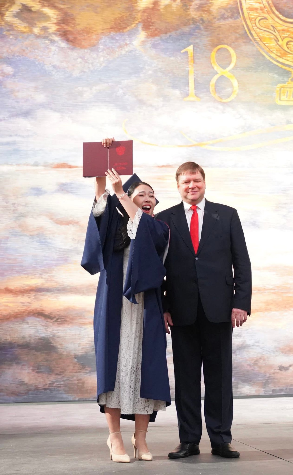 Cô du học sinh Việt Nam tự hào giơ cao tấm bằng đỏ (xuất sắc) bên cạnh GS.TS. Alexei Vasiliev -Giám đốc Nhạc viện quốc gia St.Petersburg, Liên bang Nga mang tên N.A. Rimsky Korsakov