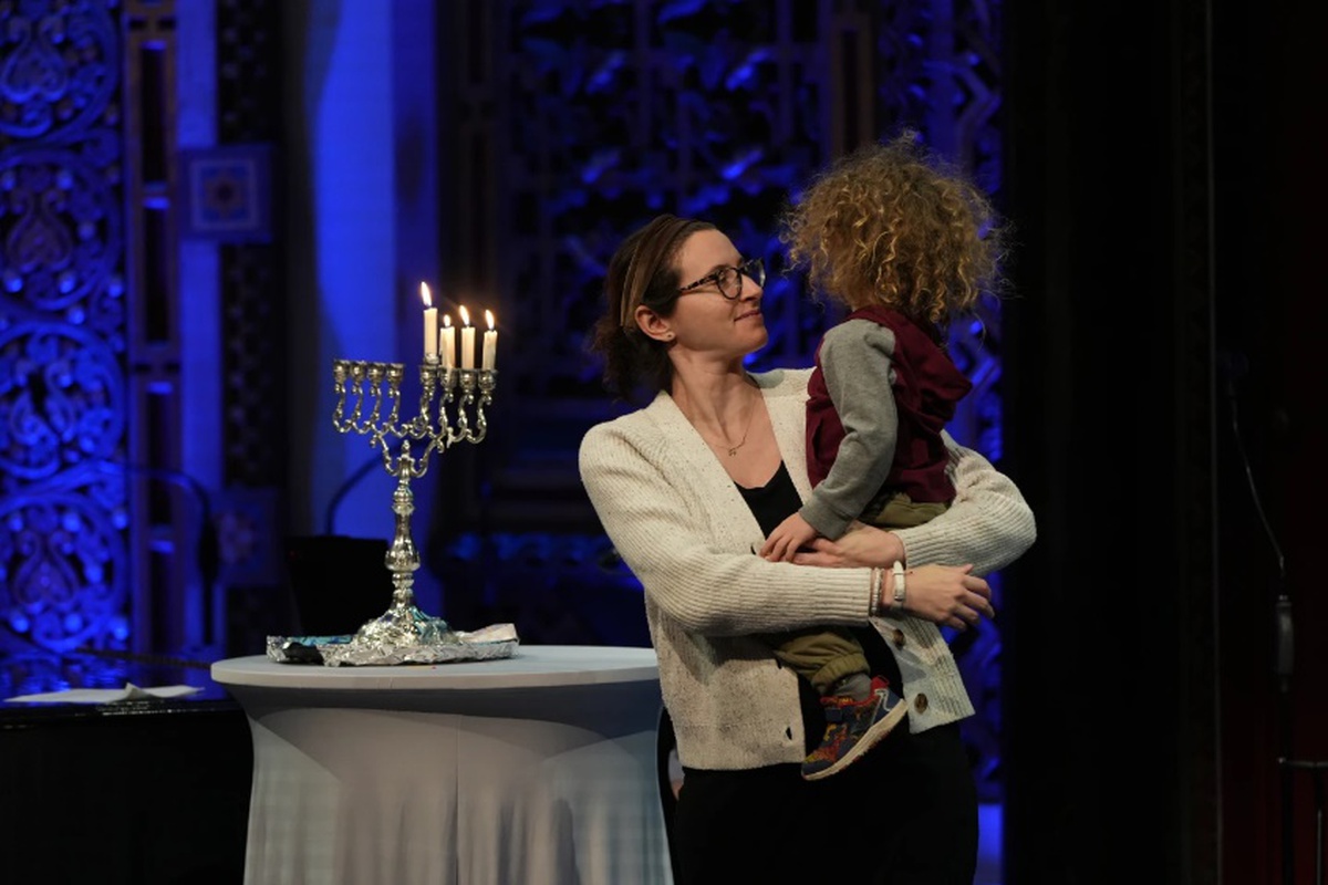 Rebecca Weintraud, trợ lý giáo đoàn B’nai Jeshurun ở thành phố New York, bế con trai trong một buổi tiệc Hanukkah tại giáo đường vào 26/12/2025