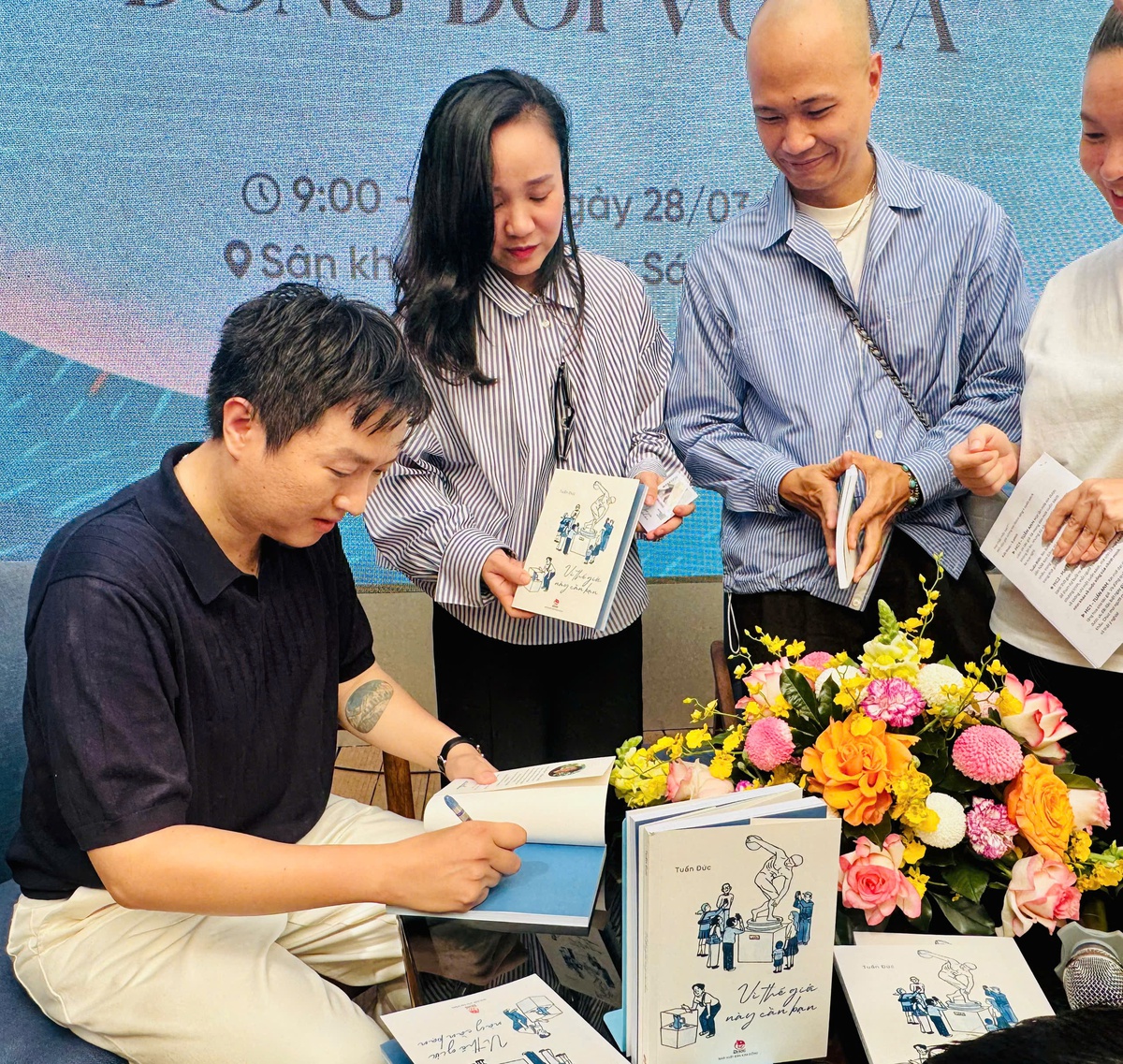 Nhà báo Tuấn Đức ký tặng độc giả. Ảnh: Hồ Lam