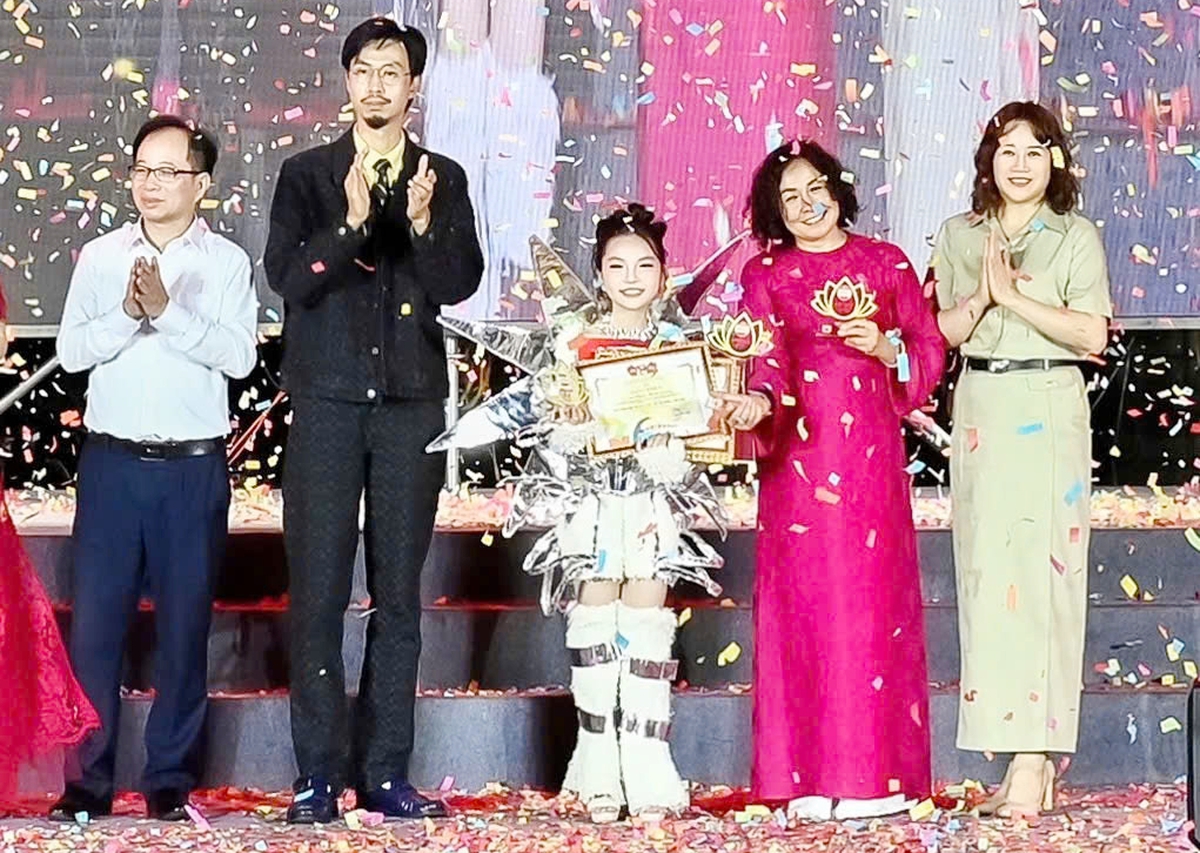 Phó Tổng Biên tập Báo Thiếu niên Tiền phong Đỗ Thị Thanh Bình (áo dài hồng) cùng nghệ sĩ Đen Vâu trao giải "Nghệ sĩ nhí đa năng" cho em Lê Ngọc Minh Giang