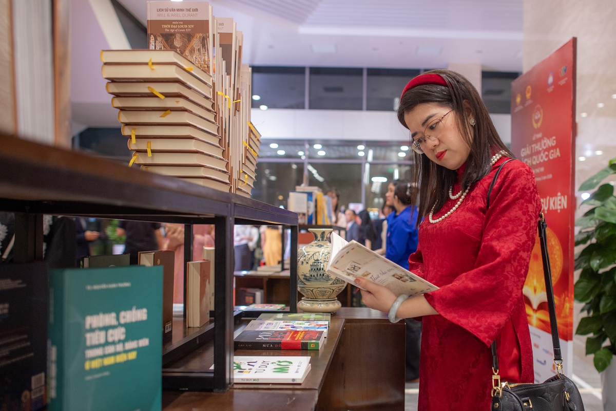 Bạn đọc chăm chú xem các tác phẩm đoạt giải tại lễ trao giải thưởng. Ảnh: Việt Linh