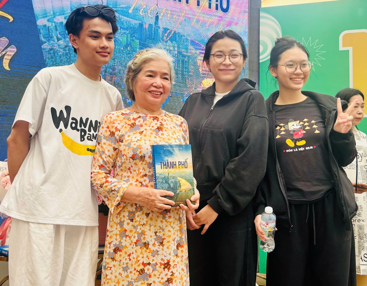 Bác sĩ Huỳnh Thị Minh Tâm chụp ảnh cùng các độc giả trẻ trong buổi ra mắt sách