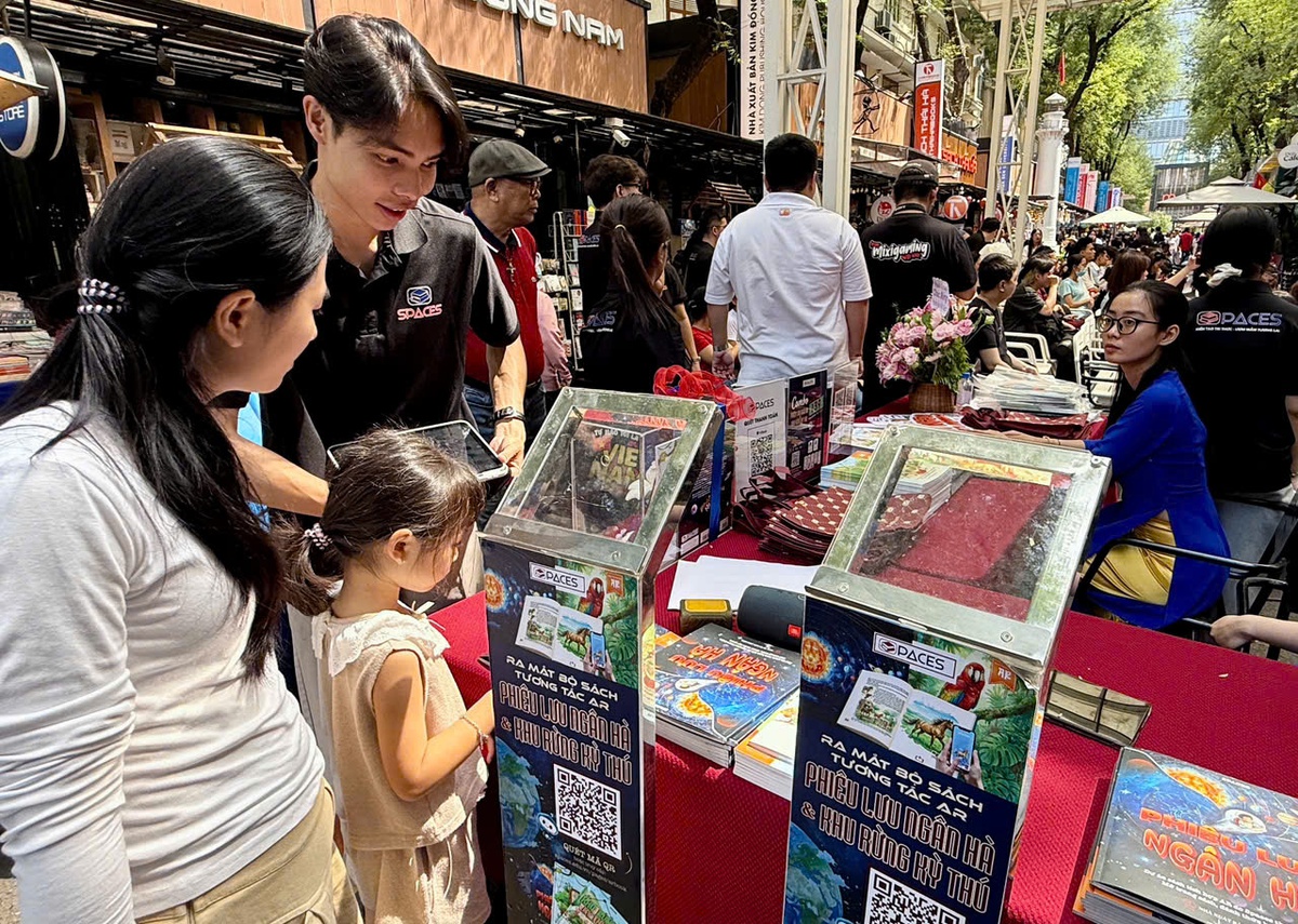 Một bạn đọc nhỏ tuổi đọc thông tin về sách để tham gia trải nghiệm