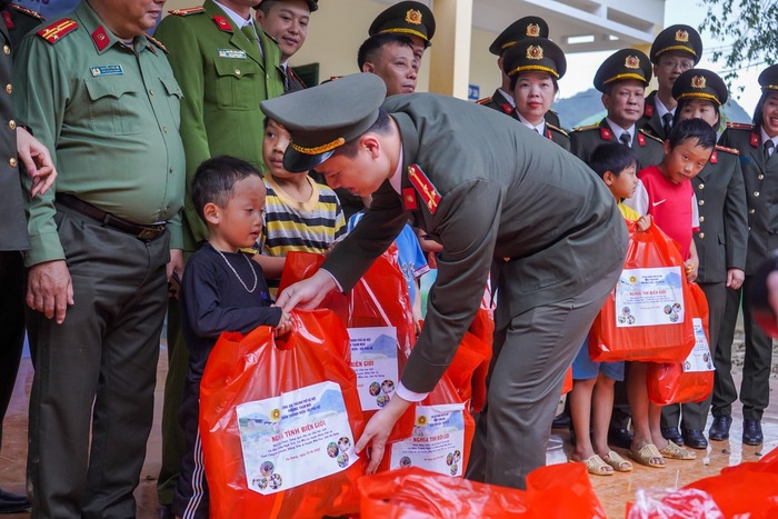 Đoàn viên Đoàn Thanh viên và  Hội viên chi hội phụ nữ phòng Tham mưu Công an thành phố Hà Nội trao những món quà nhỏ, khoác áo ấm cho các cháu