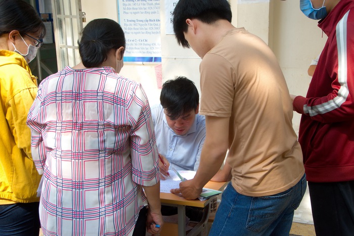 Nhân viên đang hướng dẫn người lao động hoàn tất hồ sơ tại Trung tâm Dịch vụ Việc làm TPHCM