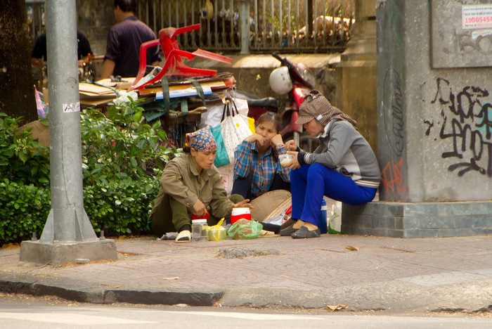 Những người buôn bán phế liệu tranh thủ vừa ăn vừa trò chuyện ngay góc ngã tư, một người buôn bán cho biết hằng ngày mưu  sinh ở ngoài nên  quen rồi, chỉ cần tránh ánh nắng trực tiếp là cũng không thấy khó chịu lắm