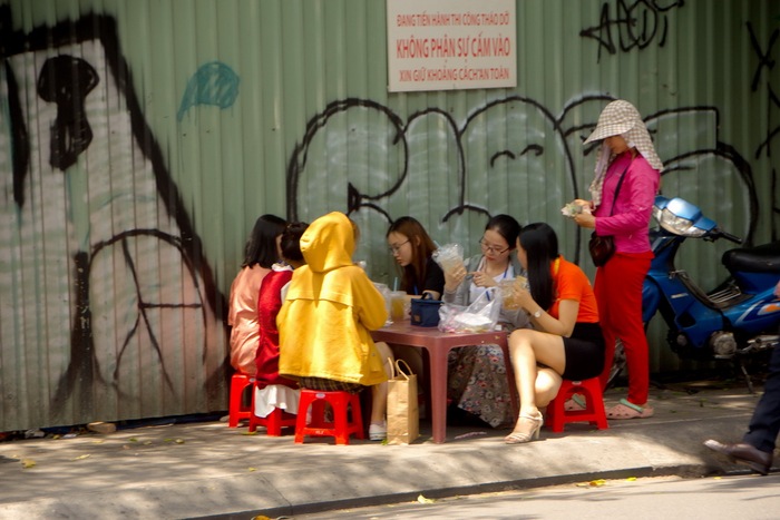 Một nhóm nhân viên văn phòng ăn cơm tại một quán dã chiến ngay dưới nắng