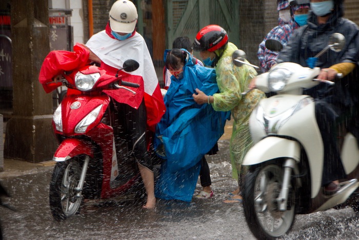 Áo mưa lùm xùm vướn víu giữ đường xá đông đúc khiến mọi thứ trở nên khó chịu trong buổi chiều đón con