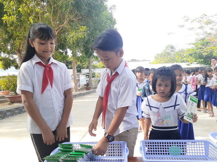Các em học sinh thực hành gấp vỏ hộp sữa sau khi uống để dễ thu gom và tái chế
