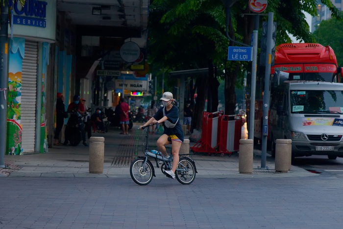 Một bạn trẻ thoải mái đạp xe trên đường Lê Lợi ngay cạnh nhà hát Thành Phố