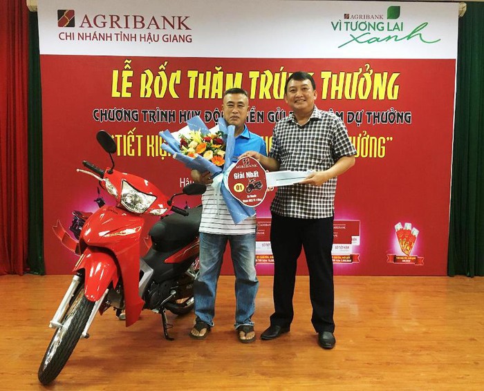 Ông Lê Hoàn Minh - Phó Giám đốc Agribank Hậu Giang (bên phải) trao giải nhất cho khách hàng