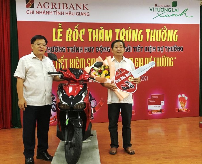 Ông Lê Viết Quyền - Giám đốc Agribank Hậu Giang (bên trái) trao giải đặc biệt cho khách hàng