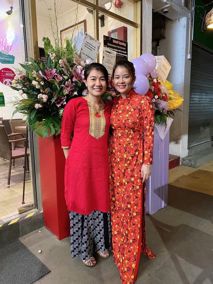 Tina Yuan cùng nhân viên và các quan khách chọn áo dài làm trang phục trong buổi khai trương nhà hàng Việt ở Singapore