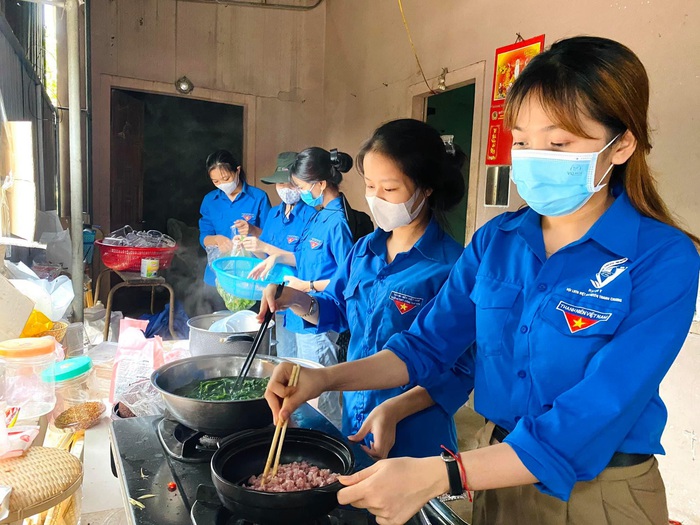 Áo xanh tình nguyện Nghệ An “đội mưa” phục vụ cơm nước, xe đưa đón miễn phí cho sĩ tử - Ảnh 1.
