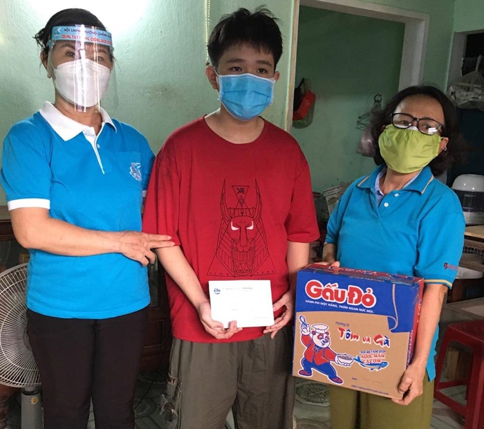 Chị Sáu (bìa trái) tặng quà cho người dân khó khăn do dịch bệnh