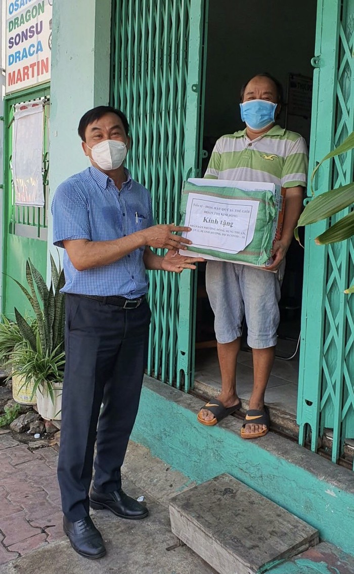 Ông Nguyễn Văn Tốt, Phó Bí thư Đảng Uỷ phường Đông Hưng Thuận, trao quà từ bà Đoàn Kim Hồng cho người dân ở địa phương