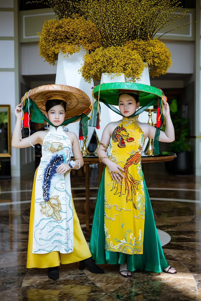 Mẫu nhí Băng Trinh (trái) và Minh Quyên (phải) làm duyên với nón quai thao và áo dài cách điệu theo dáng áo tứ thân