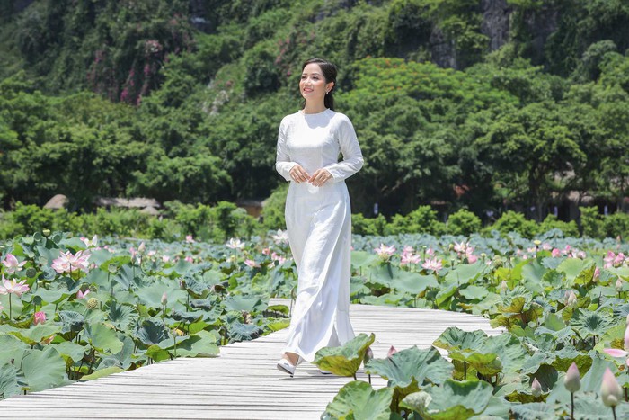 Với tà áo dài trắng tinh khôi, Vũ Diệu Thảo hóa thành cô nữ sinh trong sáng, hồn nhiên. Nụ cười tỏa nắng giữa sắc xanh của lá, sắc hồng của hoa gieo vào lòng người cảm xúc tươi mới, trong trẻo