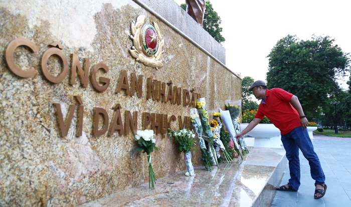Người dân đặt hoa lên tượng đài, tưởng niệm 3 cảnh sát hy sinh khi tham gia chữa cháy - Ảnh 1.