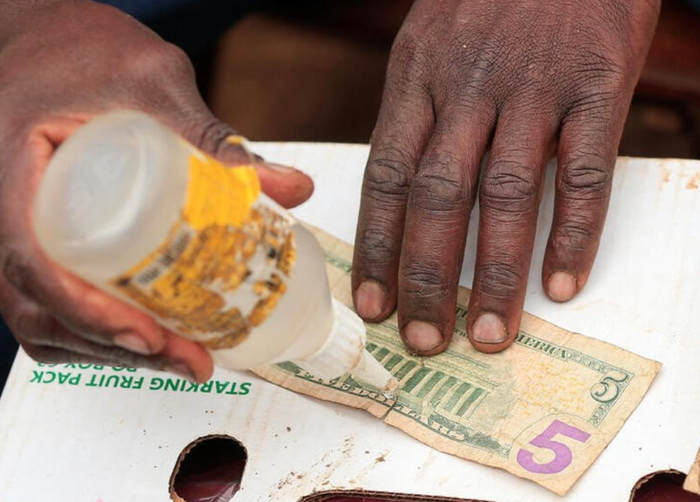 Nghề vá tiền cũ và giao dịch chợ đen ở Zimbabwe tìm được “đất sống” giữa nền kinh tế lạm phát cao nhất thế giới - Ảnh 1.