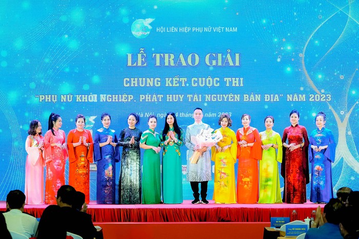 Phó Chủ tịch Hội LHPN Việt Nam Trần Lan Phương tặng hoa chúc mừng NTK Đỗ Trịnh Hoài Nam và 11 NTK đại diện hơn 6.000 nữ hội viên khởi nghiệp từ áo dài